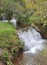 landscape with waterfall in mountainous area and temperate forest