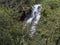 landscape with waterfall in mountainous area and temperate forest