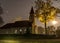 Landscape with white church in the moonlight, illuminated tree in autumn colors at night