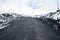 Landscape of wild Etna volcano terrain with snow and ash roads on the top of the volcano