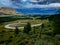 Landscape of a winding road, surrounded by grasslands, during a sunny day in South America.