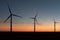 A landscape with windmills in a wind farm at sunset generating alternative and green energy source