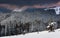 Landscape in the winter in the mountains at sunset. View of dramatic clouds and snowy wooded slopes.