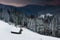 Landscape in the winter in the mountains at sunset. View of dramatic clouds and snowy wooded slopes.