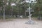 Landscape with wooden cross, stones, road and pines.