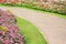 Landscaped garden background , concrete walkway , green grass and colorful ornamental flowers blooming