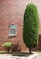 Landscaped green trees in front of a red brick