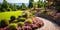 Landscaped home garden with retaining wall, tiled path and flowers in summer, scenery of upscale backyard with walkway, lawn and