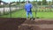 Landscaper guy working on townhouse yards renewal of lawn. Panorama shot