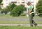 Landscaper worker cutting grass with string lawn trimmer