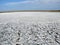 Landscapes of Genichesk pink salt lake on a background of slightly cloudy blue autumn sky.