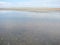 Landscapes of Genichesk pink salt lake on a background of slightly cloudy blue autumn sky.