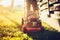 Landscaping and gardening. Worker using industrial lawnmower