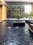 Landscaping near a modern building in Dubai - fountains and palm trees in marble tubs