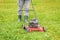Landscaping worker pushing lawnmower on lawn