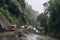 landslide blocking a road, with rescue vehicles on standby