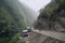 landslide blocking a road, with rescue vehicles on standby