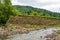 Landslide in the village. Rocks and ground are destroyed. Sunny weather. Plants die. Cataclysms. The texture of the stones.