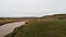 Landswell line of Kara sea in cloudy afternoon on Yamal peninsula. Strong wind makes large foamy waves.