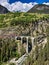 Landwasser viaduct in the Davos mountains near Filisur. Beautiful old stone bridge with a moving train. Spring Time