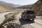 Langar, Tajikistan, August 23 2018: Off-road car is waiting on the Pamir Highway on the Pamir River