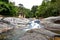 LANGKAWI, MALAYSIA - OCTOBER 15.2019: Tourists swimming under Seven Wells Waterfall on Langkawi island Malaysia