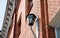 Lantern on the wall of a red brick building. Elements of urban architecture. View from below