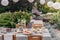 Lanterns above table with flowers, food and drink in the garden with hanging chair and plants.