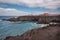 Lanzarote landscape. Los Hervideros coastline, lava caves, cliffs and wavy ocean. Unidentifiable tourist are in the background