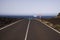 Lanzarote - Timanfaya NP: Driving trip on endless empty asphalt road between black lava rocks in barren landscape to atlantic