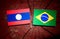 Laos flag with Brazilian flag on a tree stump isolated