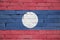 Laos flag is painted onto an old brick wall