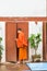 Laotian monk enters the building in Louangphabang, Laos. Copy space for text. Vertical.