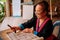 Laotian Senior woman do Batik fabric painting