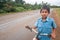 Laotian young boy in school uniform with bicycle on the National Highway T 16 from Salavan to Pakse, Laos. Asphalt road on Bolaven