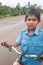 Laotian young boy in school uniform with bicycle on the National Highway T 16 from Salavan to Pakse, Laos. Asphalt road on Bolaven