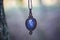 Lapis lazuli gemstone ornamental pendant on blury forest background