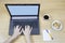 Laptop with blank screen female hands on keyboard coffee crackers on light wooden floor background