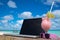 Laptop blank screen on wooden desk with beach. relax concept.