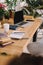 laptop with blank screen on wooden table with potted plants