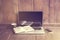 Laptop, book and cell phone on a wooden floor