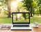 Laptop and coffee on wood workspace and park background