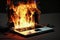 Laptop computer engulfed in flames and burning