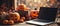 Laptop computer on Happy Halloween decorations table background.