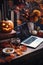 Laptop computer on Happy Halloween decorations table background.