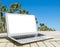 Laptop computer on wooden table. Top ocean view. Tropical island background. Open blank laptop computer empty space. Front view