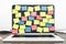 Laptop display with empty colored sticker notes on brown office table