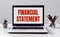 Laptop with Financial Statement text on modern office background