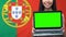 Laptop with green screen in female hands, Portugal flag background traveling app