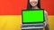 Laptop with green screen in womans hands, German flag background, traveling app